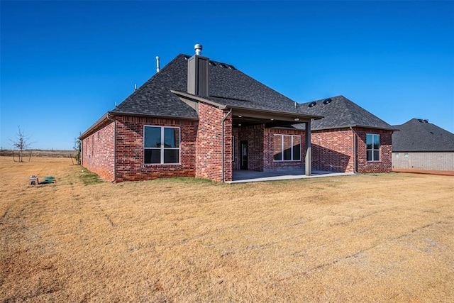 rear view of property with a lawn and a patio area