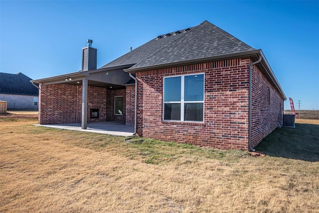 back of property with a yard and a patio area