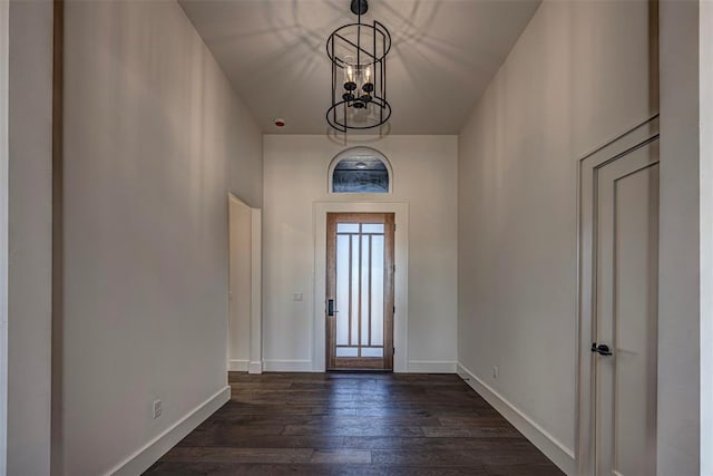 foyer entrance with an inviting chandelier and dark wood-type flooring