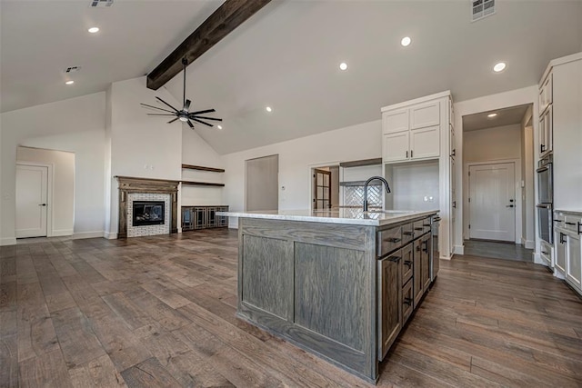 kitchen featuring dark hardwood / wood-style floors, white cabinetry, sink, and a kitchen island with sink