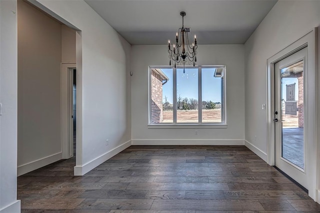 unfurnished dining area featuring a chandelier and dark wood-type flooring