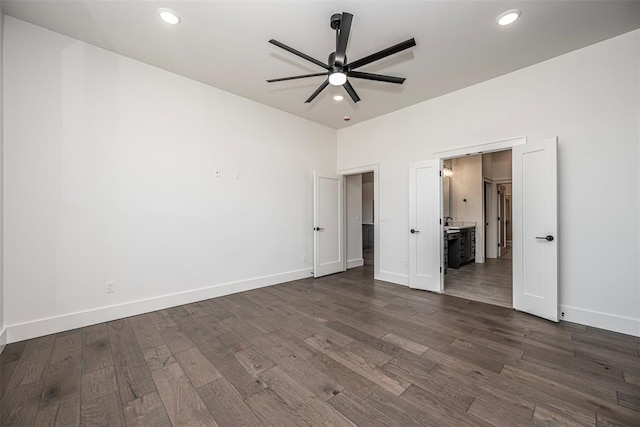 unfurnished bedroom featuring dark hardwood / wood-style flooring, ceiling fan, and connected bathroom