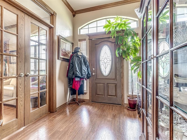 entrance foyer with french doors, wood-type flooring, and ornamental molding