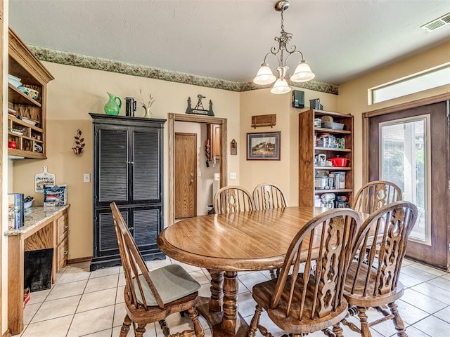 dining area with light tile patterned floors and a notable chandelier