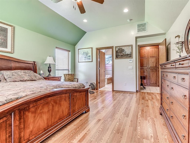 bedroom featuring light wood-type flooring, connected bathroom, ceiling fan, and lofted ceiling