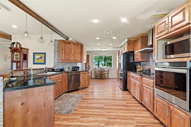 422502 E 1100th Rd, Checotah, OK 74426 - kitchen featuring stainless steel appliances, wall chimney range hood, a peninsula, dark countertops, and light wood finished floors