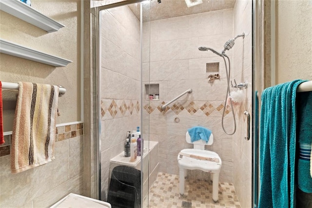 422502 E 1100th Rd, Checotah, OK 74426 - bathroom with a shower stall, tile walls, and a textured wall