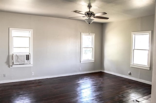 spare room with cooling unit, plenty of natural light, dark wood-type flooring, and ceiling fan