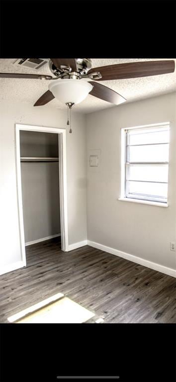 unfurnished bedroom with a closet, ceiling fan, and dark hardwood / wood-style floors