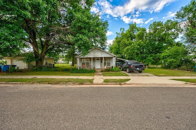 bungalow with covered porch, a front yard, and a carport