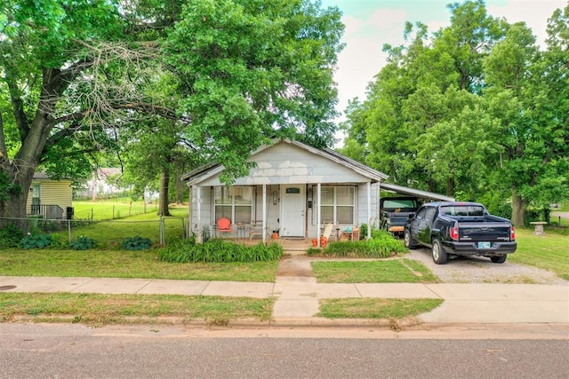 bungalow-style home with a front lawn and a carport