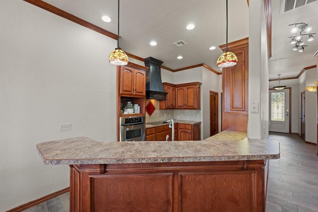 kitchen featuring kitchen peninsula, custom range hood, oven, and wood-type flooring