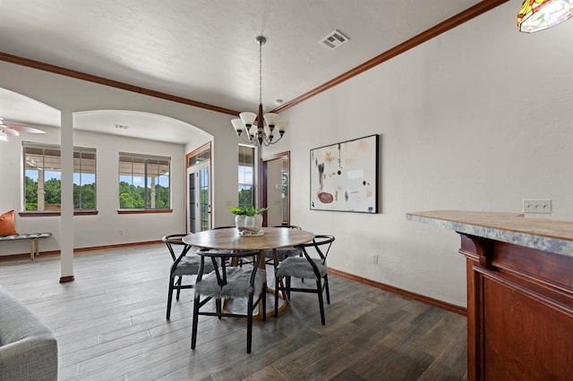 dining space featuring ceiling fan with notable chandelier, dark hardwood / wood-style floors, and ornamental molding