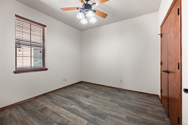 spare room with dark hardwood / wood-style floors and ceiling fan