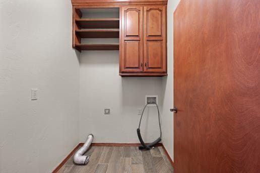 washroom with washer hookup, hookup for an electric dryer, cabinets, and light hardwood / wood-style flooring