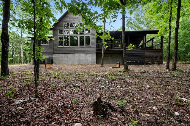 rear view of property with cooling unit and a deck