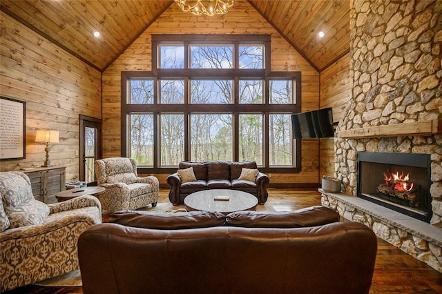 living room with high vaulted ceiling, wood-type flooring, wooden walls, a fireplace, and wood ceiling