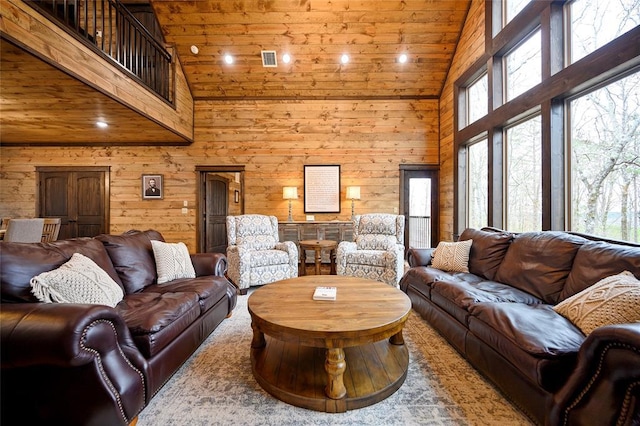 living room with high vaulted ceiling, wood ceiling, and wooden walls