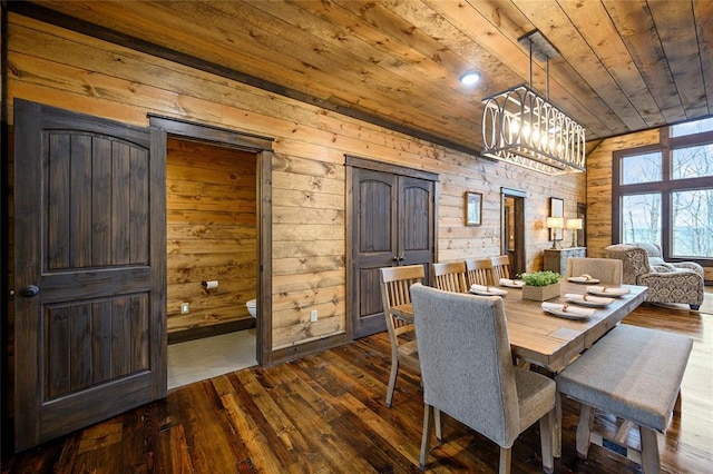 dining area featuring wooden walls, hardwood / wood-style floors, a chandelier, and wooden ceiling