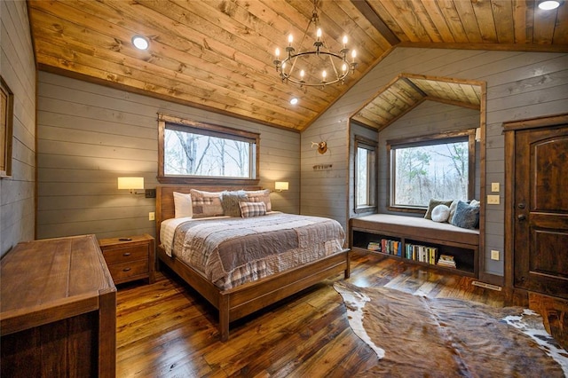 bedroom with hardwood / wood-style floors, wood walls, an inviting chandelier, vaulted ceiling, and wood ceiling