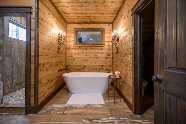 bathroom featuring a washtub, wooden ceiling, hardwood / wood-style floors, toilet, and wooden walls