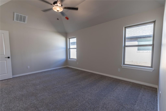 carpeted empty room featuring ceiling fan, plenty of natural light, and lofted ceiling