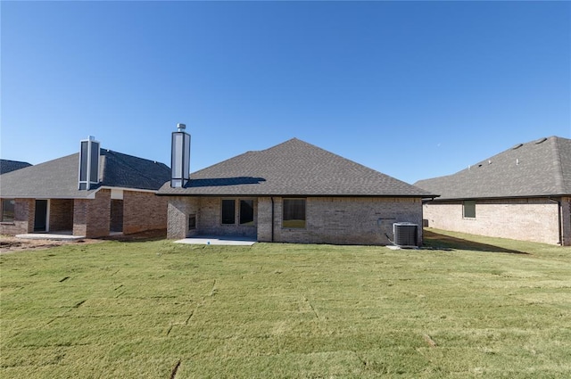 rear view of property with a yard, central AC unit, and a patio area