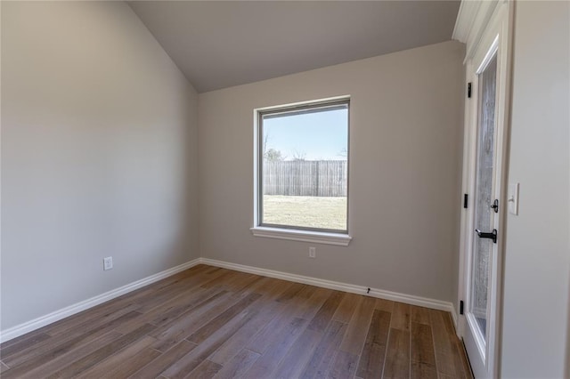 unfurnished room featuring hardwood / wood-style flooring and lofted ceiling