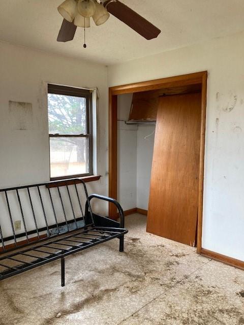 interior space with ceiling fan and a closet