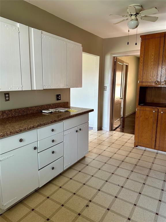 kitchen with white cabinets, ceiling fan, and dark stone countertops