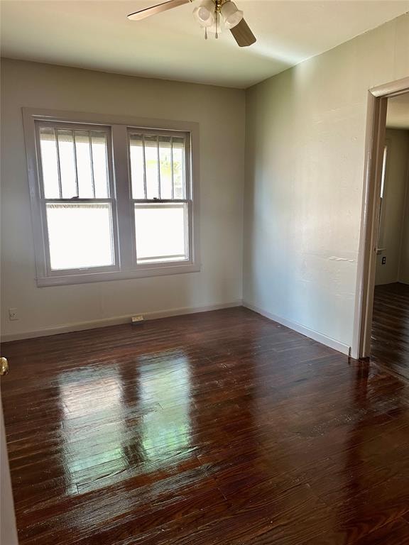 unfurnished room featuring a wealth of natural light and dark wood-type flooring