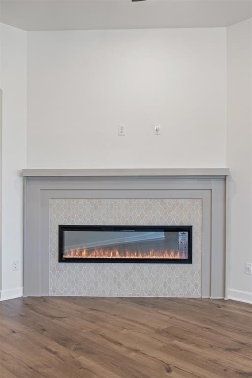 details featuring a tile fireplace and hardwood / wood-style flooring