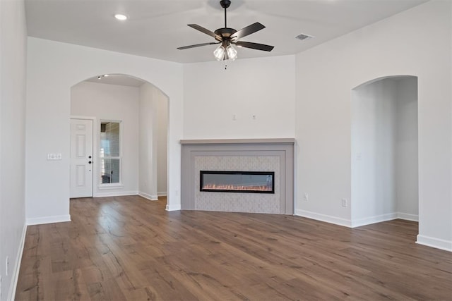 unfurnished living room with dark hardwood / wood-style floors and ceiling fan