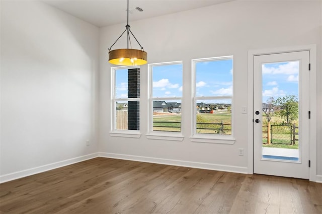 unfurnished dining area featuring hardwood / wood-style flooring and plenty of natural light