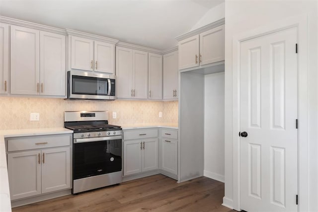 kitchen with hardwood / wood-style flooring, white cabinetry, appliances with stainless steel finishes, and tasteful backsplash