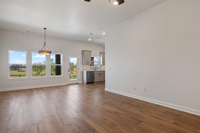 unfurnished living room featuring ceiling fan, dark hardwood / wood-style flooring, and sink