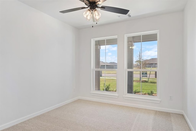 empty room featuring carpet, plenty of natural light, and ceiling fan