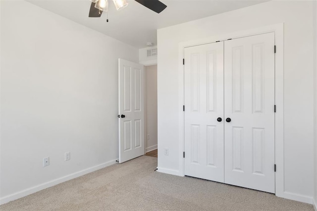 unfurnished bedroom featuring ceiling fan, a closet, and light colored carpet