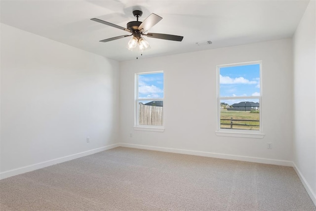 carpeted spare room with ceiling fan and a healthy amount of sunlight