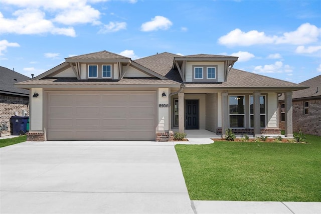 view of front of house with a front lawn, covered porch, and a garage