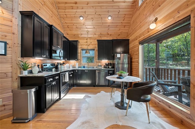 kitchen featuring wooden ceiling, wooden walls, light hardwood / wood-style floors, and appliances with stainless steel finishes