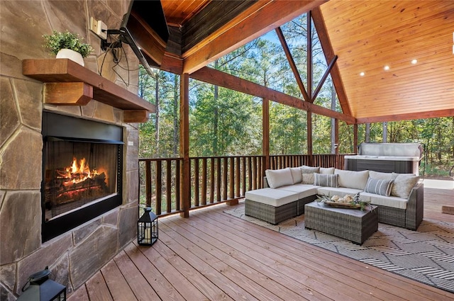 wooden terrace with an outdoor living space with a fireplace and a grill