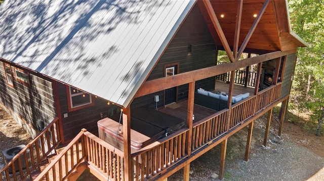 rear view of property with cooling unit and a hot tub