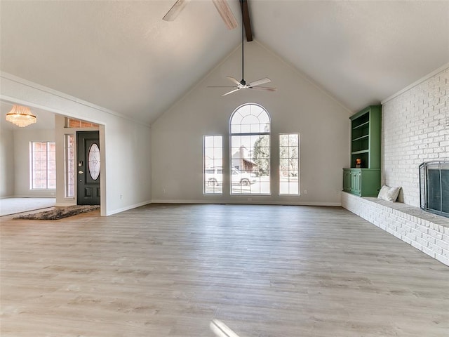 unfurnished living room featuring beamed ceiling, light wood-type flooring, a fireplace, and ceiling fan