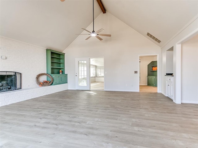 unfurnished living room with ceiling fan, light hardwood / wood-style flooring, lofted ceiling with beams, and a brick fireplace