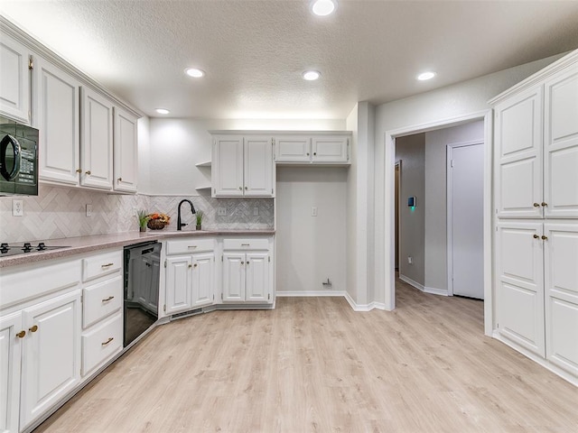 kitchen featuring black appliances, decorative backsplash, white cabinets, and light hardwood / wood-style flooring