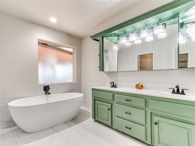 bathroom with vanity, a tub to relax in, and tile walls