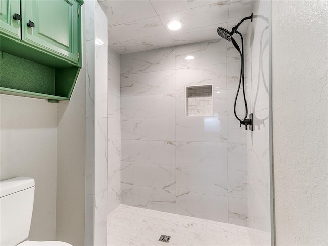 bathroom with toilet and tiled shower