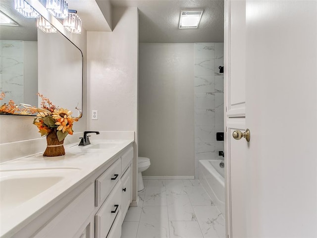 full bathroom featuring a textured ceiling, vanity, tiled shower / bath combo, and toilet