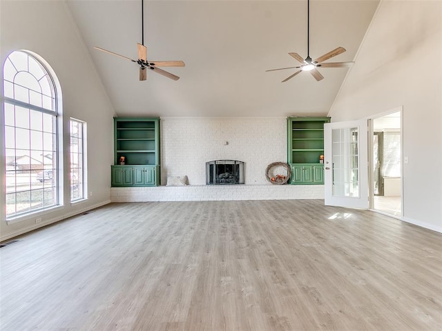 unfurnished living room featuring hardwood / wood-style flooring, a fireplace, and high vaulted ceiling